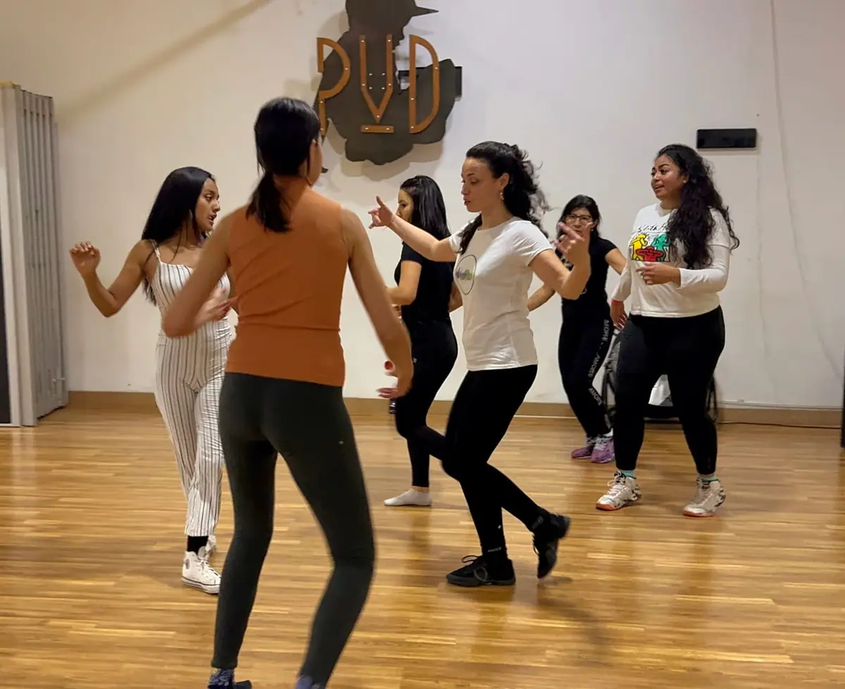 Un grupo de mujeres bailando samba juntas en una sala de baile Un grupo de mujeres bailando samba en un salón de piso de madera
