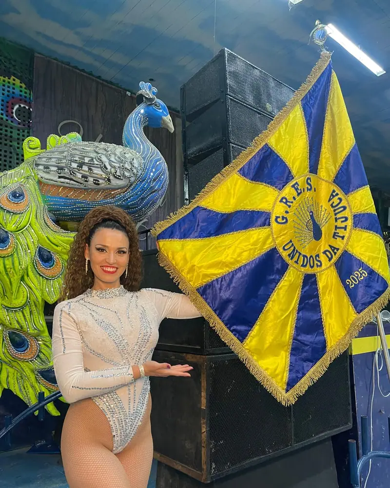Naty junto al pabellón bordado de una escola de samba