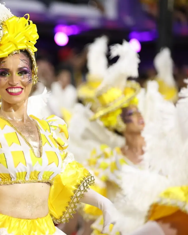 Naty con traje amarillo y plumas blancas durante el Carnaval