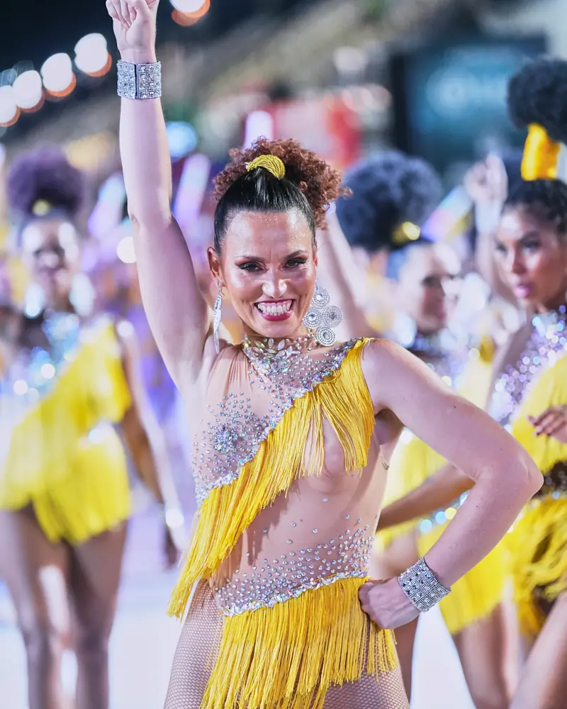 Natalia Ferrer bailando samba con traje amarillo de flecos, con el brazo levantado, en el Carnaval de Río