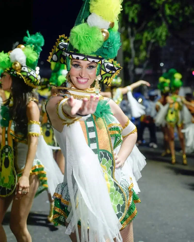 Naty con traje verde y blanco y tocado de plumas en el Carnaval