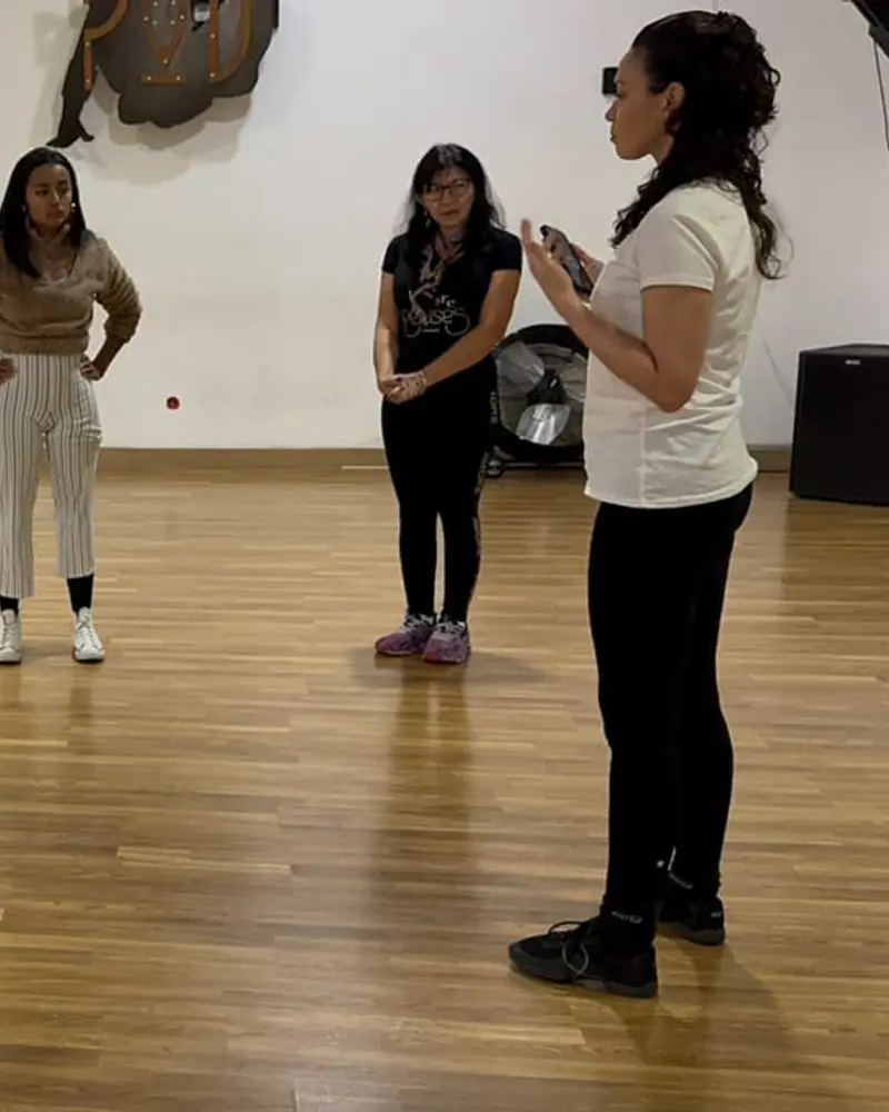 Naty marcando un paso frente a un grupo de mujeres