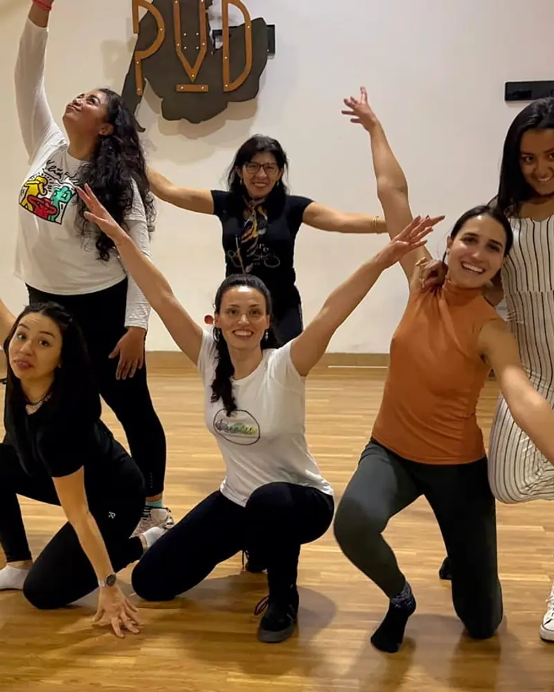 Un grupo de mujeres posando y riendo después de bailar